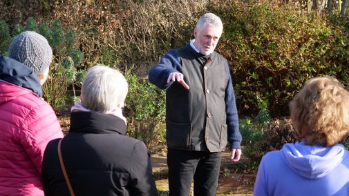 A guide giving a talk in a garden